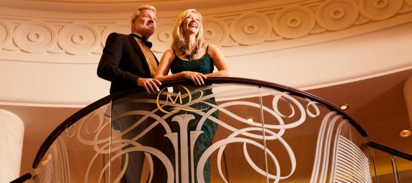 Couple in formal wear on the Grand Lobby staircase | The Cunard Experience