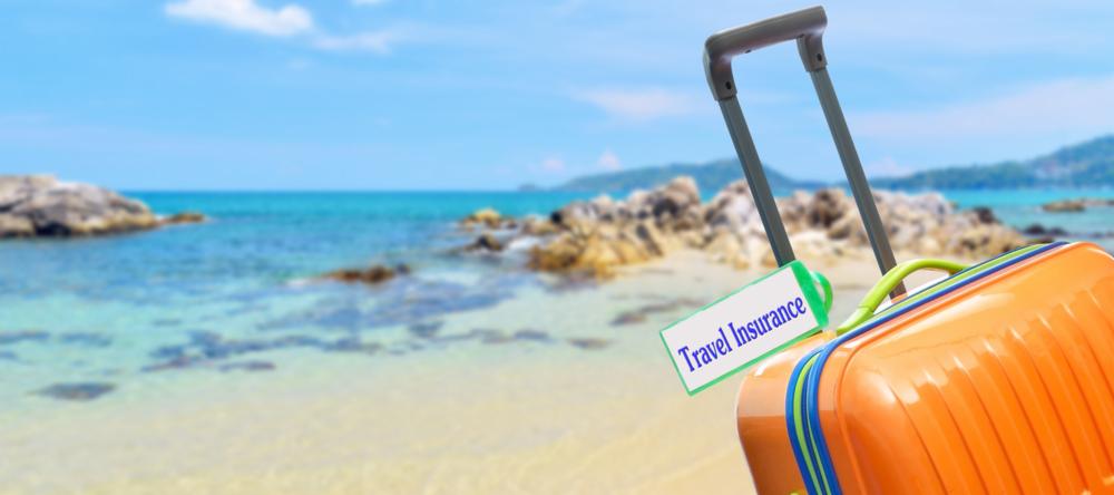 Suitcase on beach | The cost of not having travel insurance