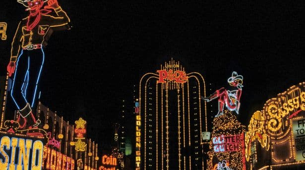 Bright neon signs and lights illuminating the Las Vegas Strip at night.
