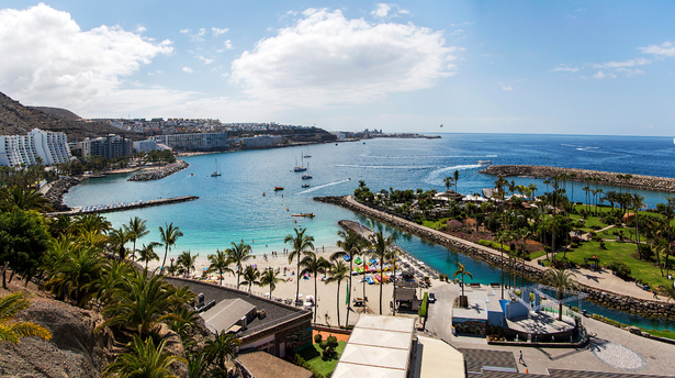 A scenic view of Gran Canaria’s beaches, marinas, and palm-lined coast - a top destination for families seeking sunshine and fun attractions.