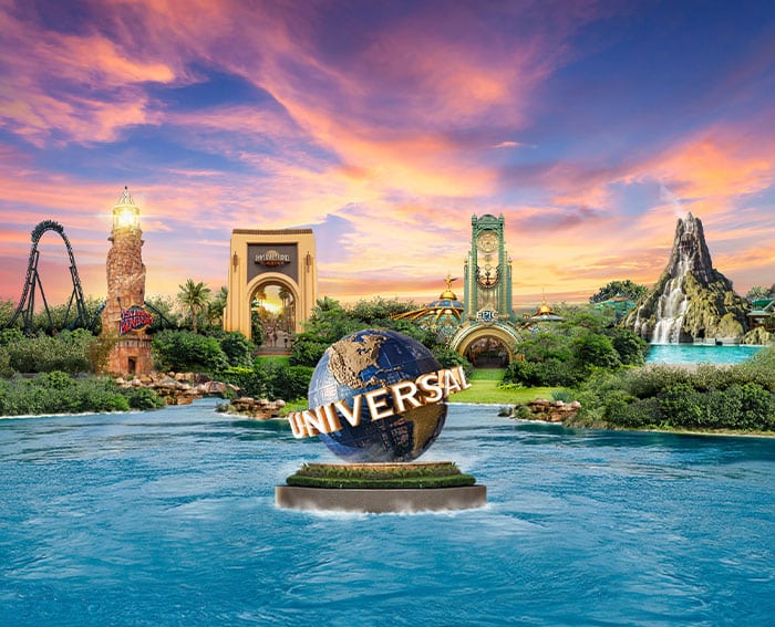 Universal Orlando Resort skyline at sunset featuring the iconic Universal globe, Islands of Adventure lighthouse, Universal Orlando entrance arch, Epic Universe portal and a volcano backdrop, showcased by Click