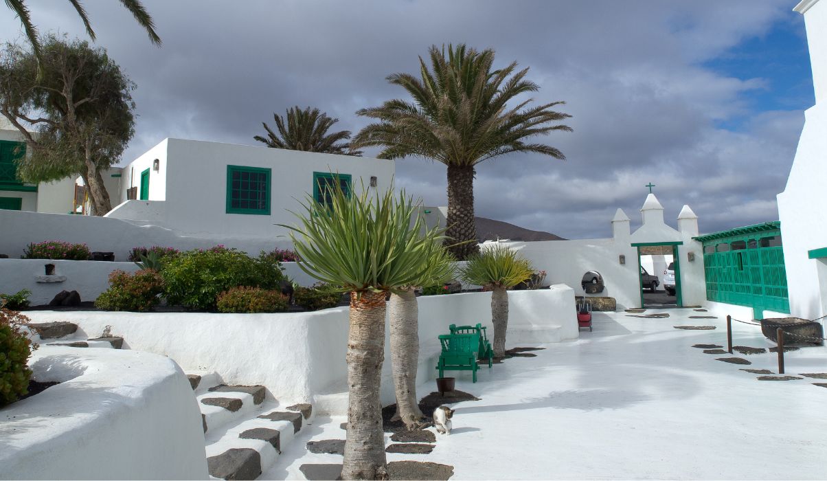 Traditional white buildings and palm trees in Lanzarote on a cloudy day