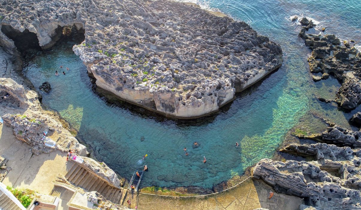natural pool surrounded volcanic rock with vibrant turquoise waters