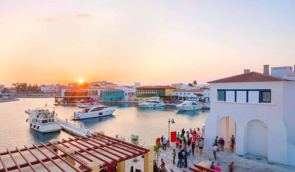 Boats docked in the Agia Marina as the sunsets along the water.