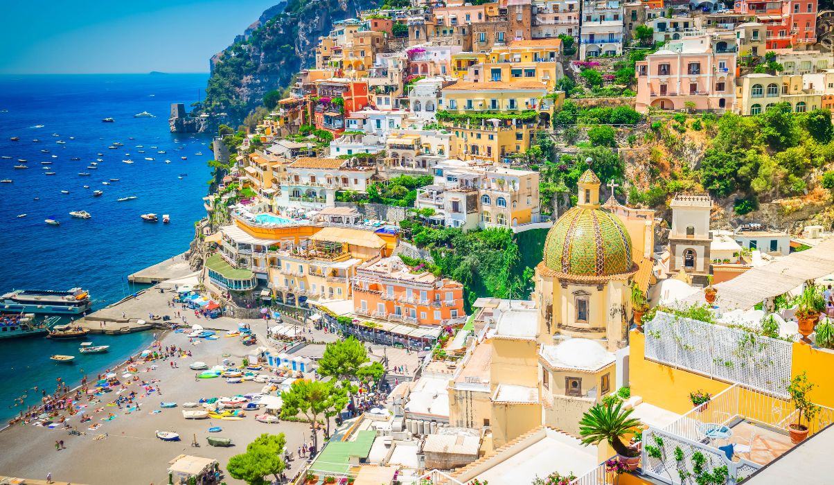 Iconic view of the famous Positano with its charming colourful buildings, sandy beach and bright blue ocean.
