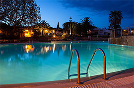 The main pool in Rocha Brava by night