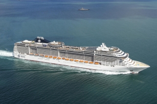 Aerial view of the cruse ship MSC Divina  going through the blue and green waters